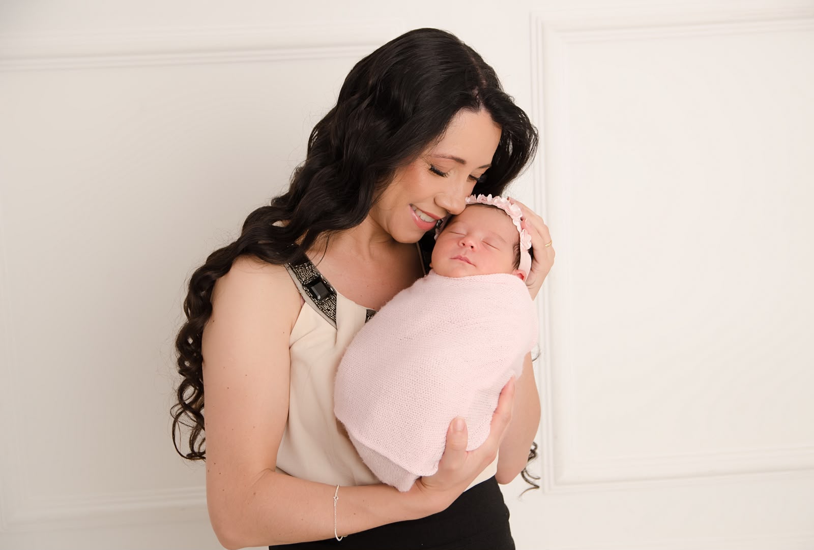 Mãe abraçando seu bebê em um ensaio newborn