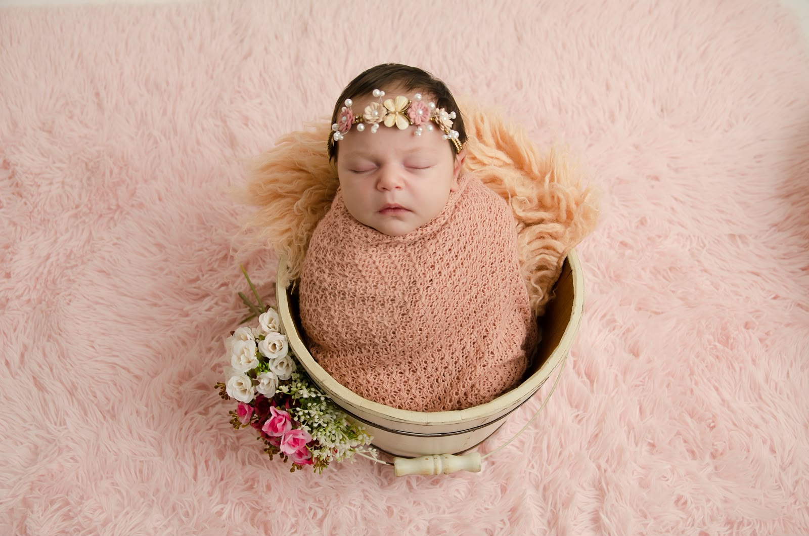 Bebê recém-nascido em composição com flores